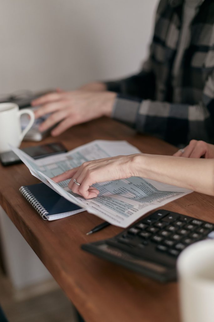 Profesionales revisando documentos fiscales junto a una calculadora